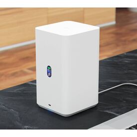 Λευκό NAS Ubiquiti UNAS-2-W σε γραφείο· ο υπολογιστής εμφανίζεται μόνο ως σκηνικό και δεν περιλαμβάνεται